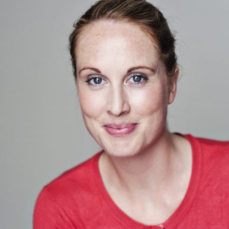 Headshot of Amy Allen in a red shirt with hair brushed back into a ponytail