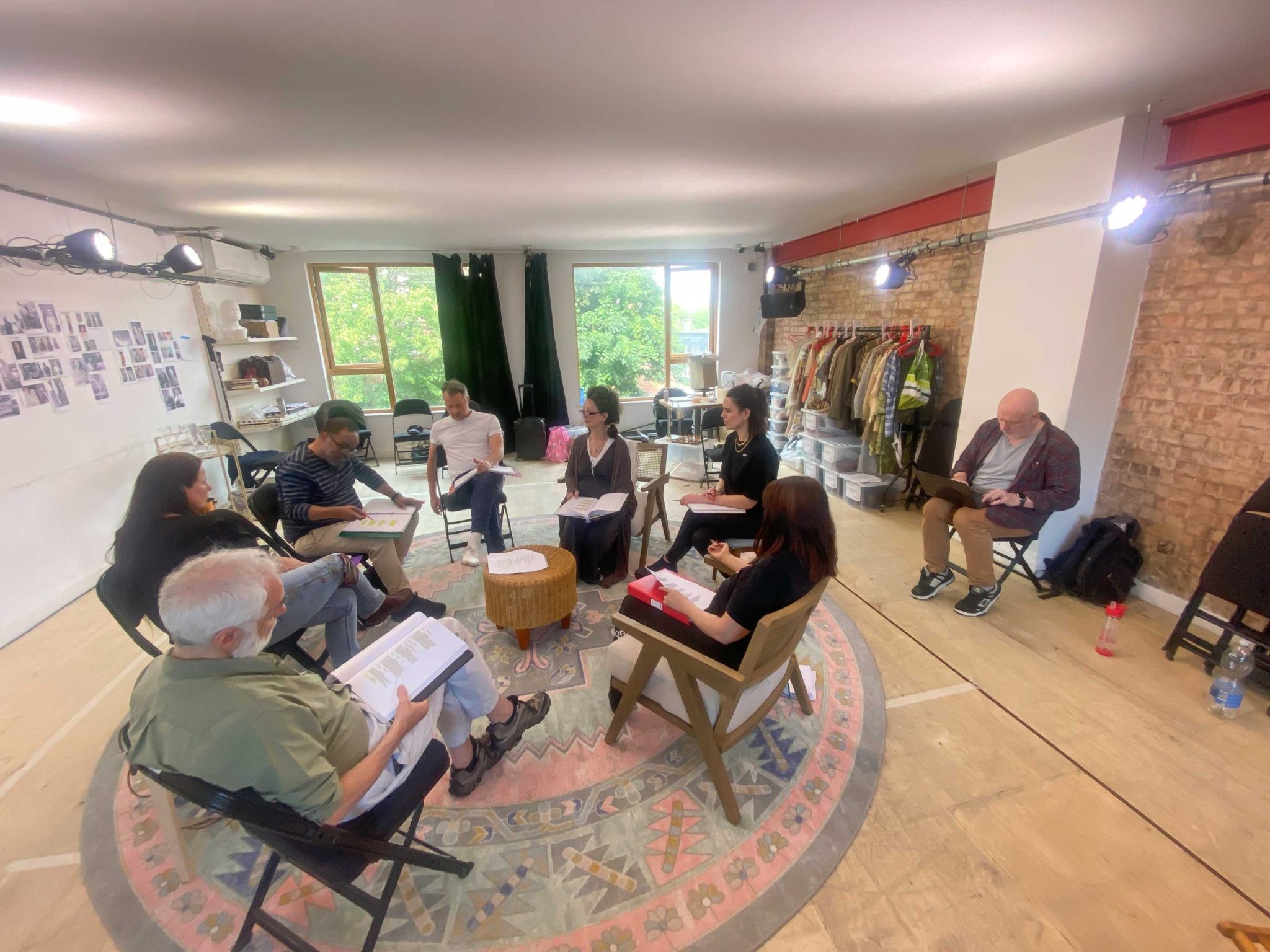 Morris Space, with 8 people sitting on chairs with scripts reheasring a play