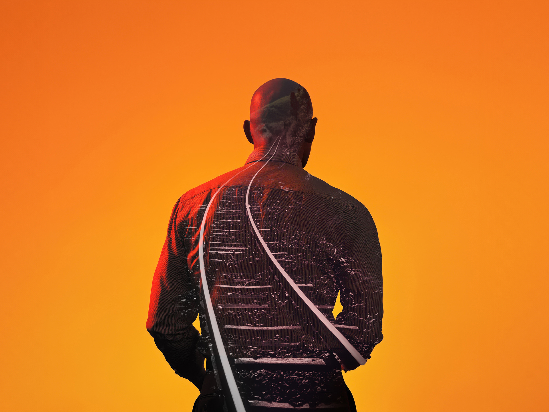 The silhouette of a man with a train track projected on his back.